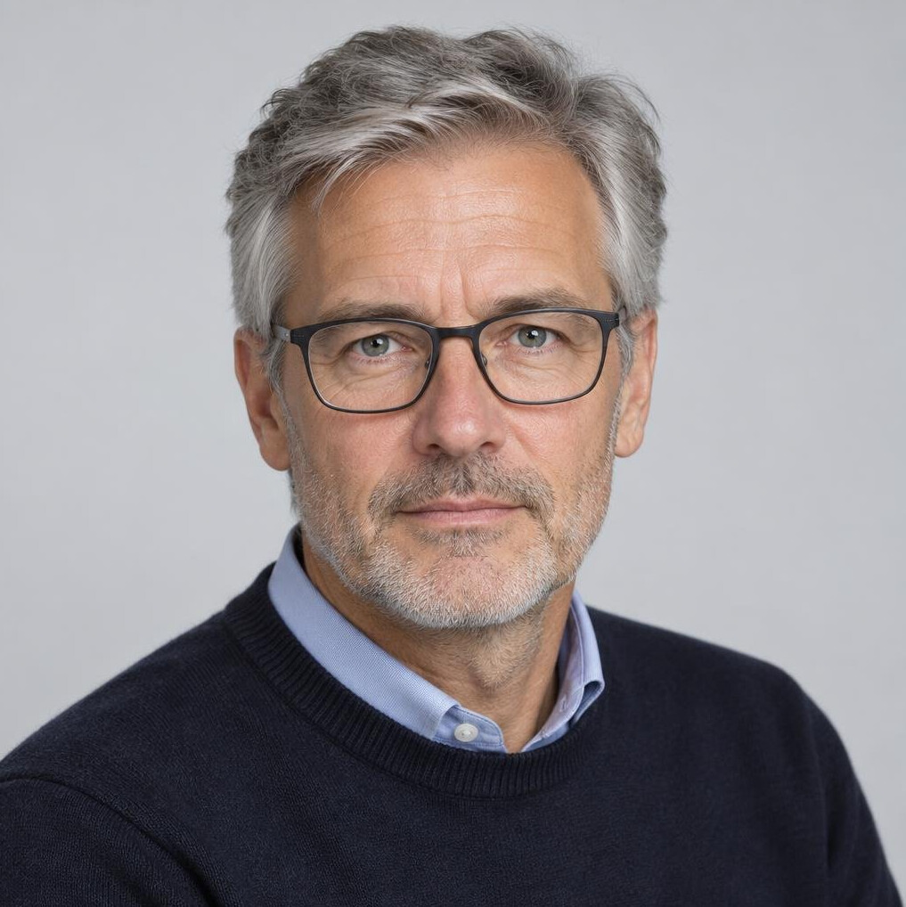 Studio portrait of a man in his 50s with glasses, serious expression